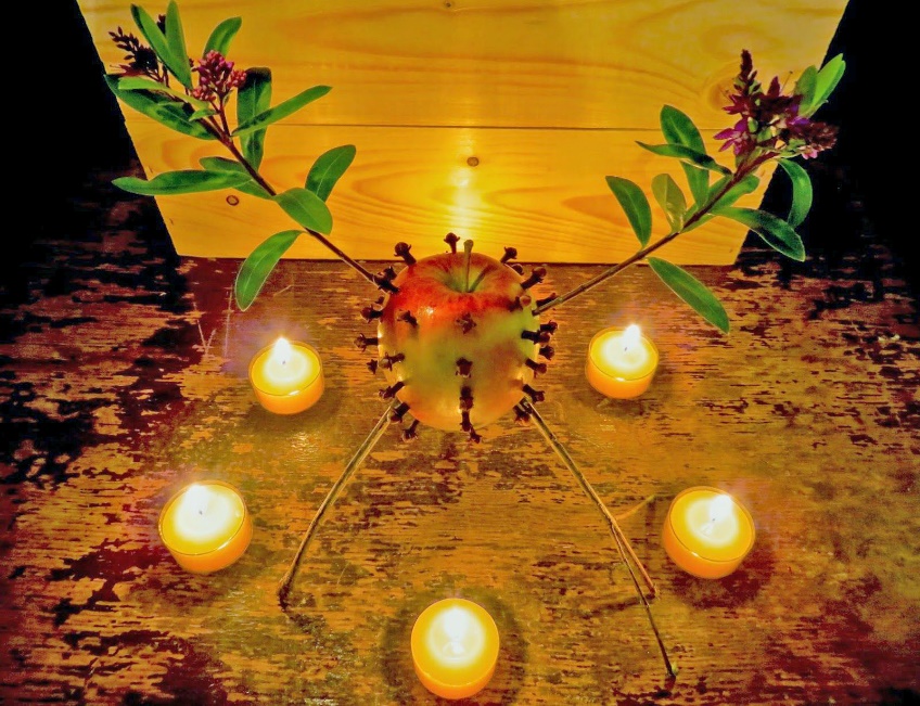 Clove-studded apple surrounded by candles in a midwinter folk ritual