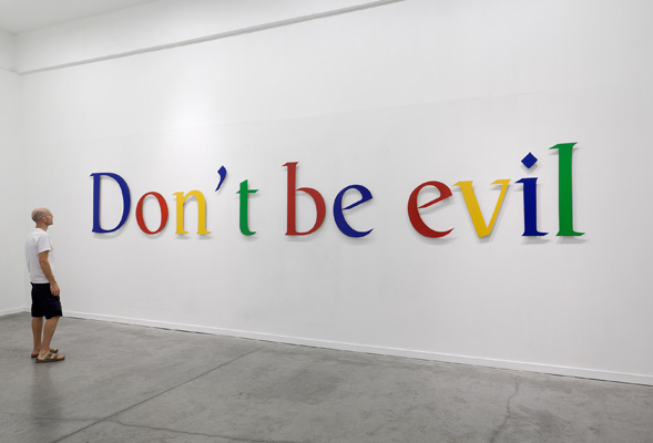 A person viewing the words Don’t be evil in Google’s colors.